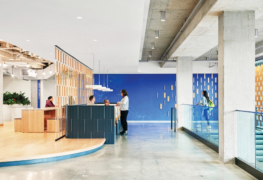 A woman standing in a lobby with a blue wall