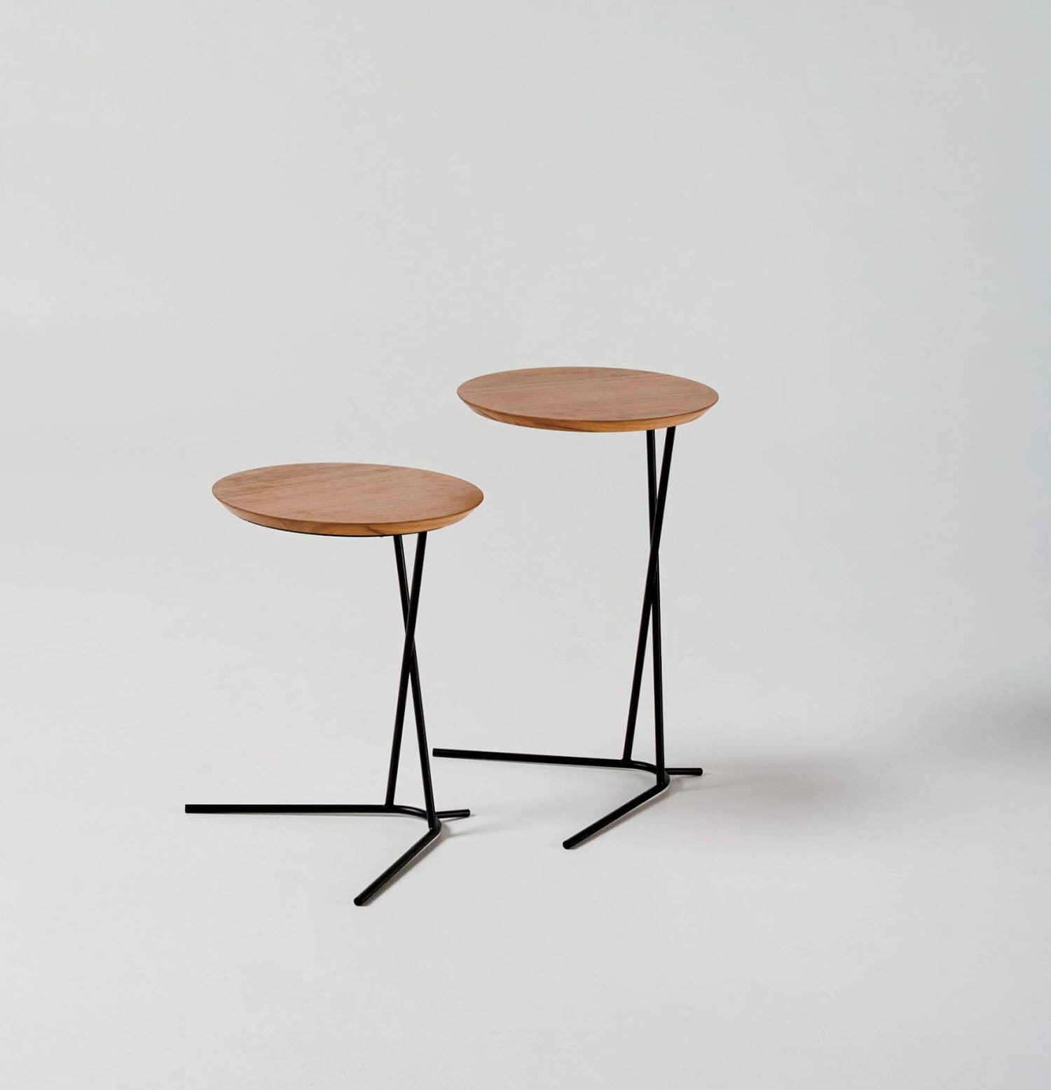 Two tables with black legs and a wooden top.