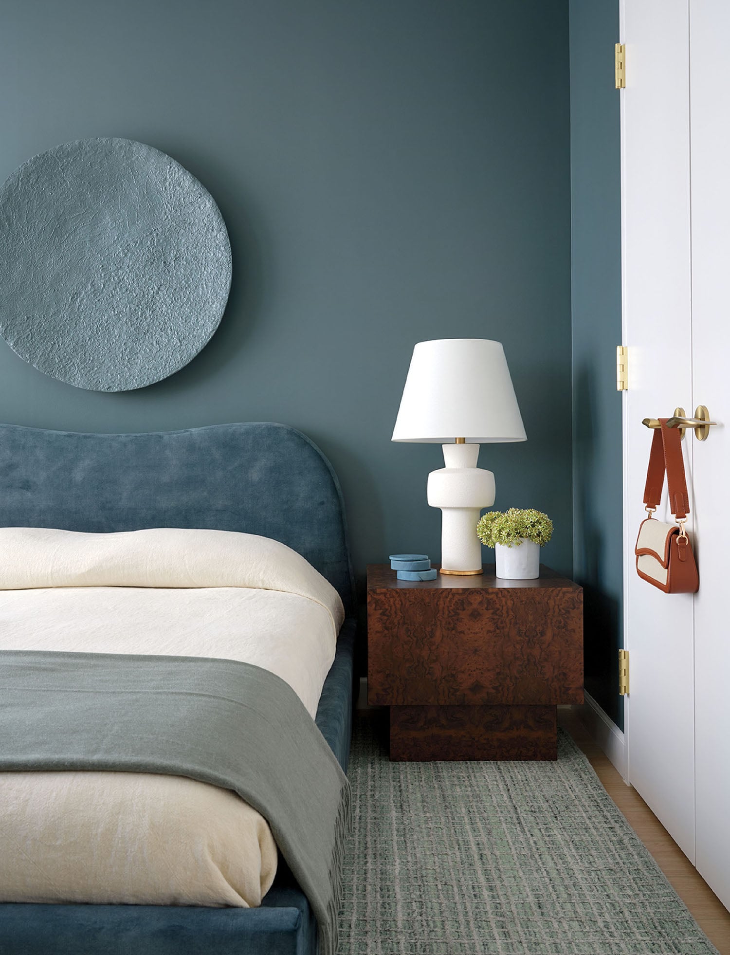 A bedroom with a bed and a blue wall.