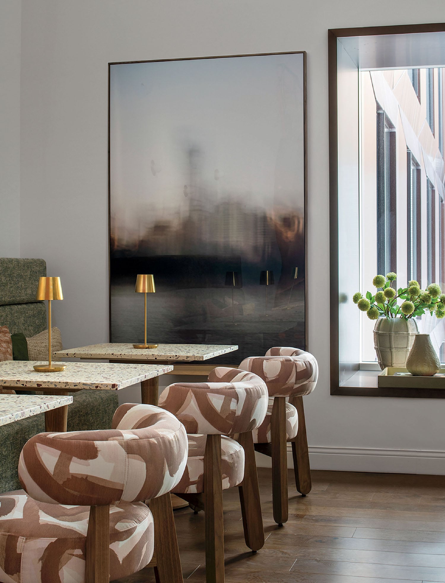 A room with a table, chairs, and a large picture.
