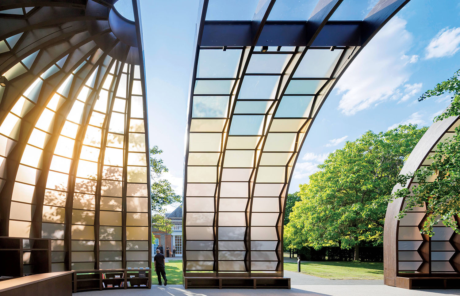 A man walking through a glass covered walkway.