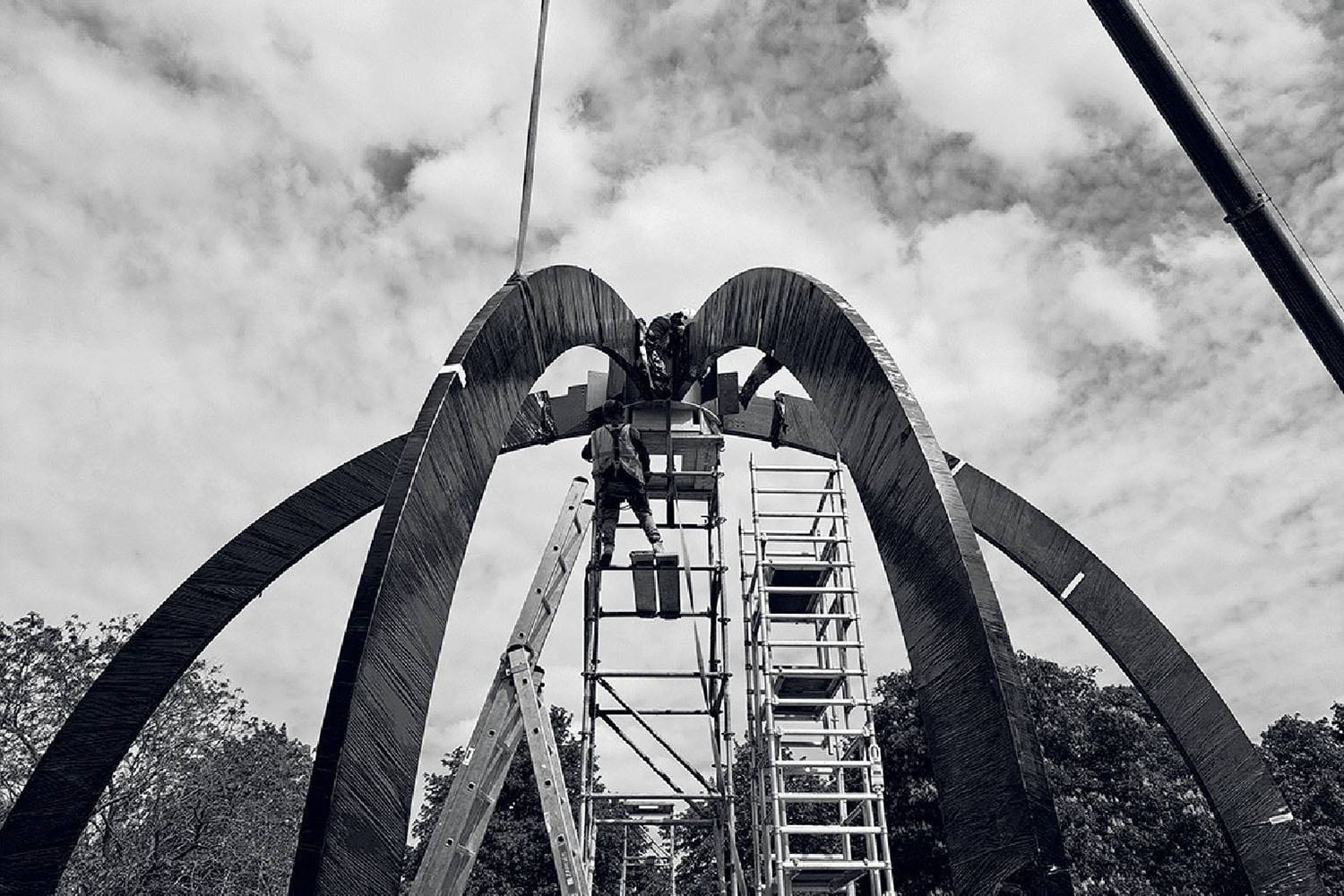 A man is working on a large sculpture.