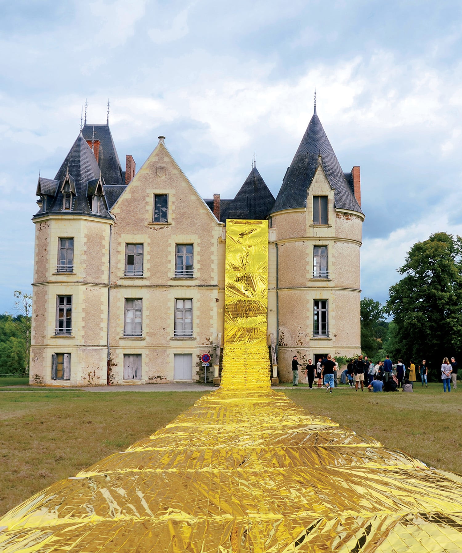 a giant yellow piece of cloth is in front of a castle