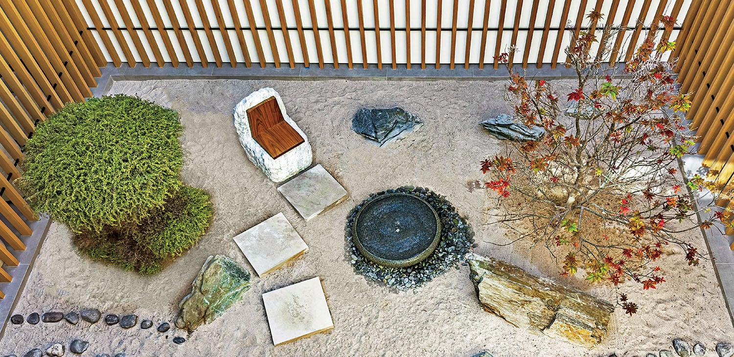 A small garden with a fountain and a pot.