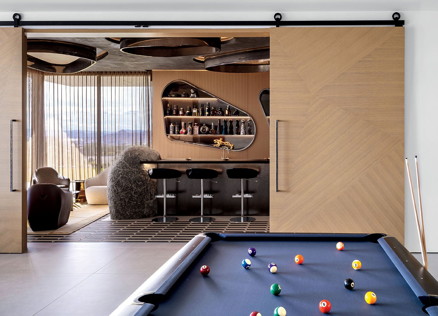 A pool table with pool balls and a pool chair.