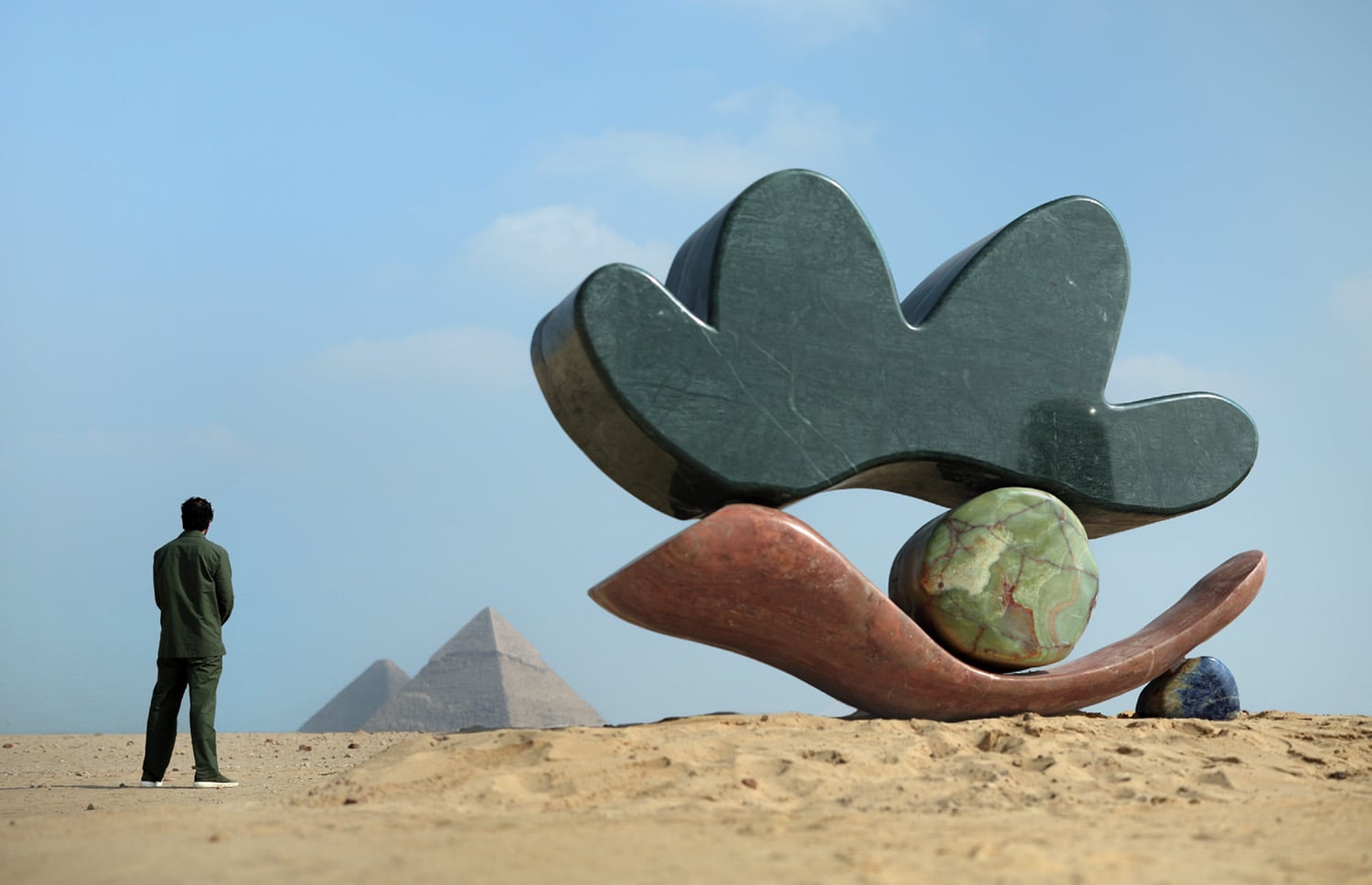A man standing next to a sculpture of a flower.