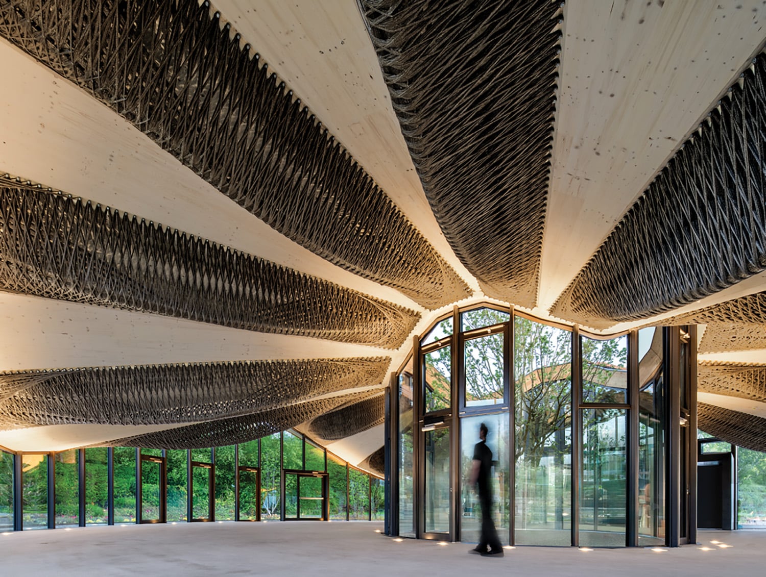 A person standing in a room with a large ceiling.