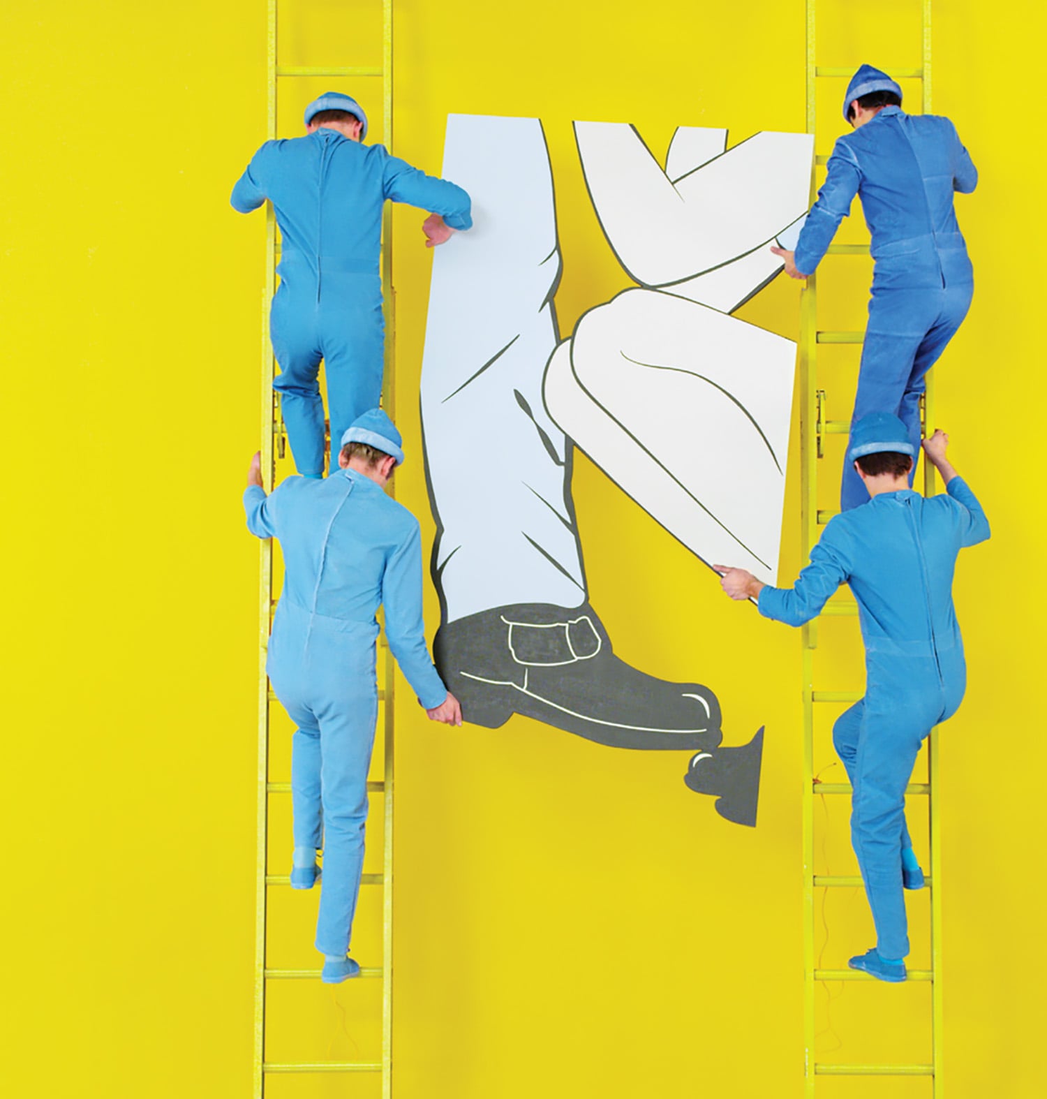 Two men in blue overalls and blue overalls are painting a large.