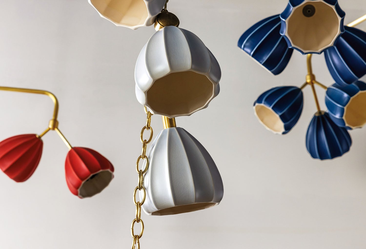 A bunch of colorful paper flowers hanging from a ceiling.