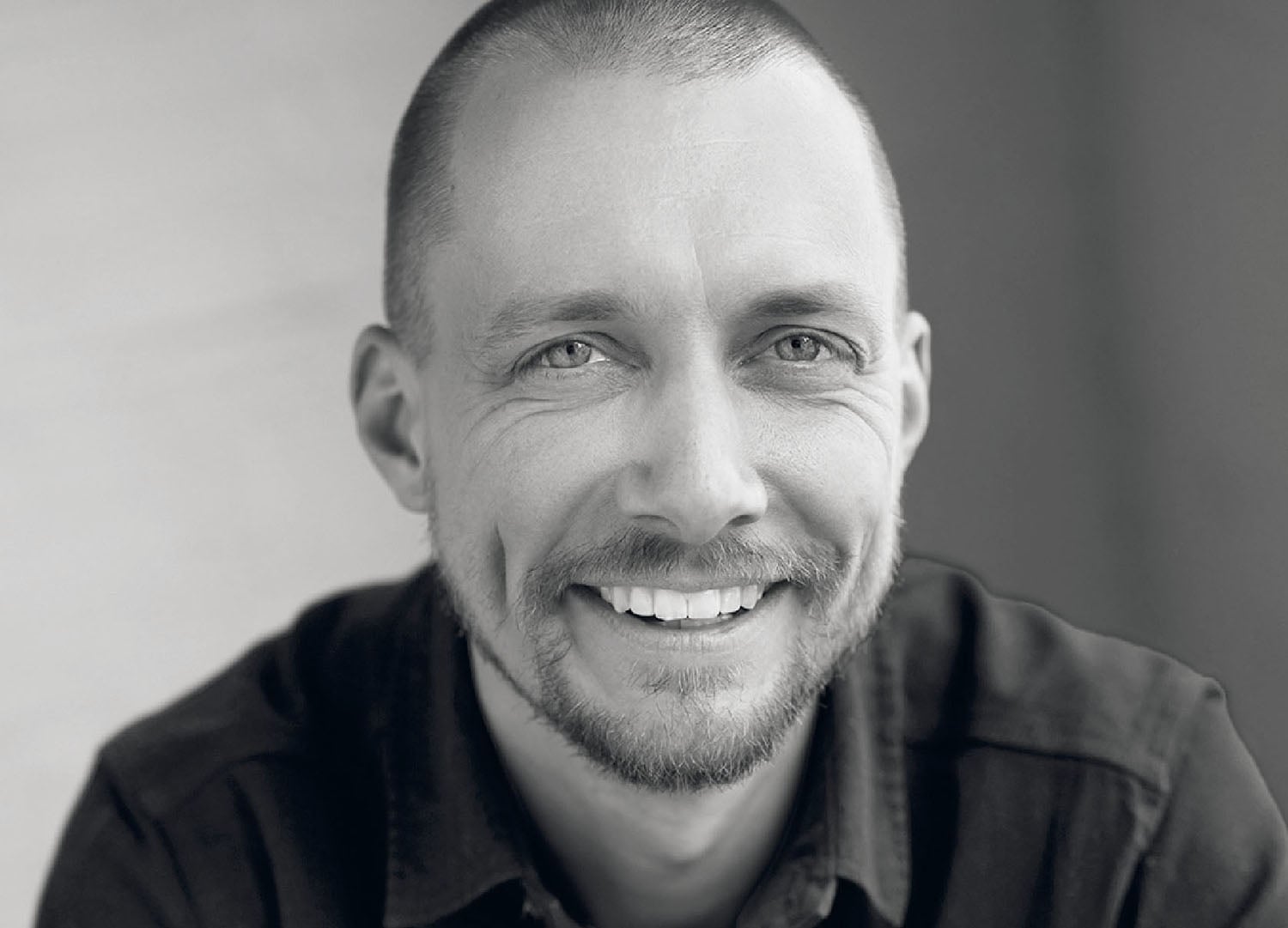 A man with a beard smiles at the camera.