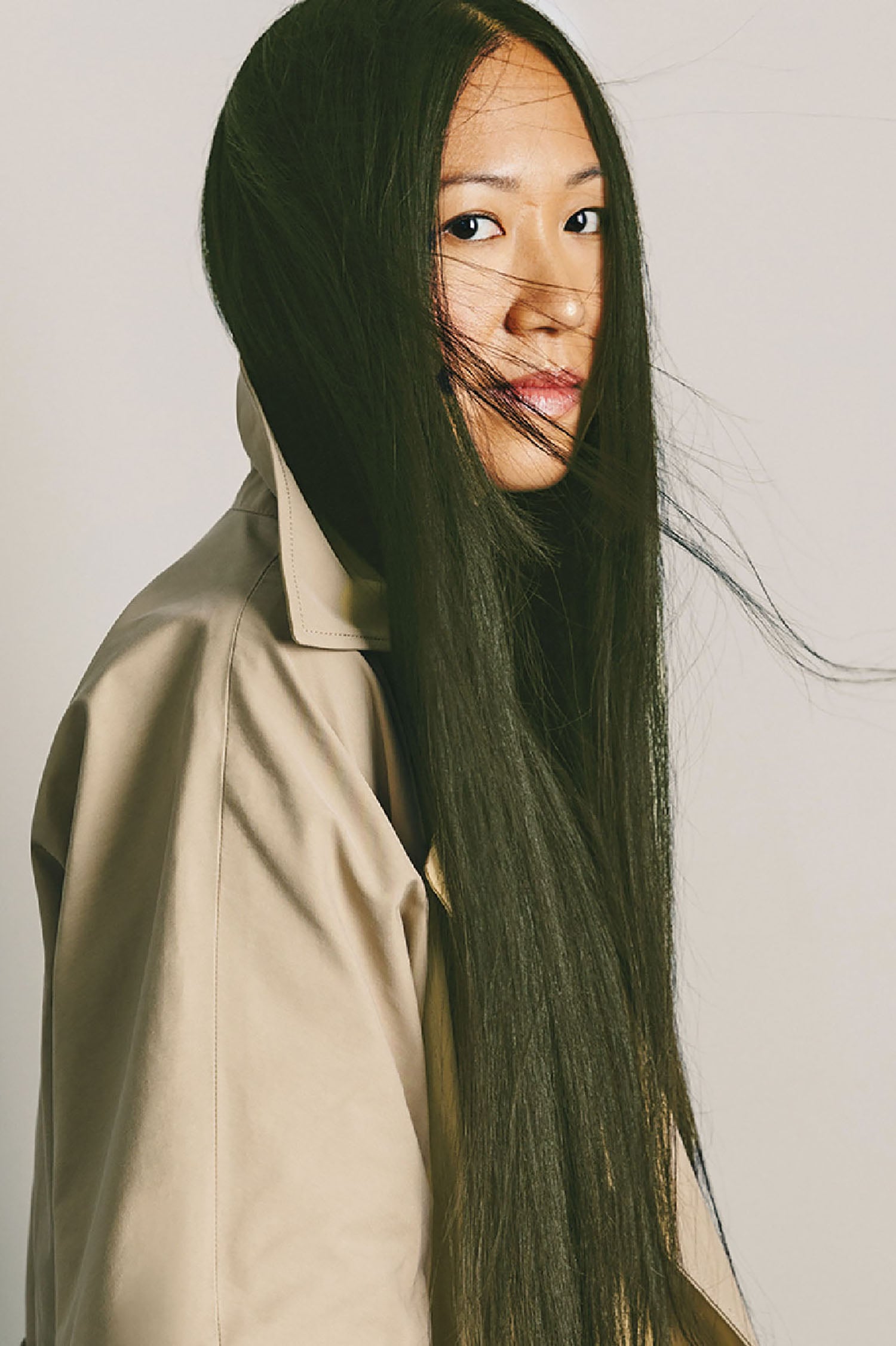 A woman with long hair and a trench coat.