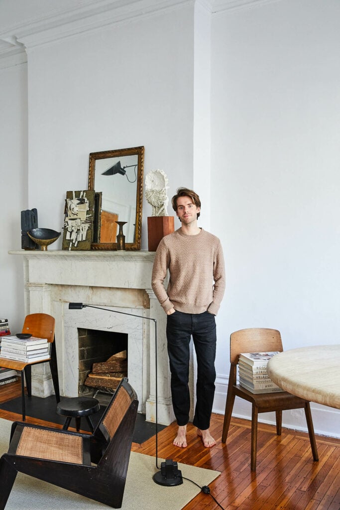 interior designer and stylist Colin King dressed in a tan sweater and black plants