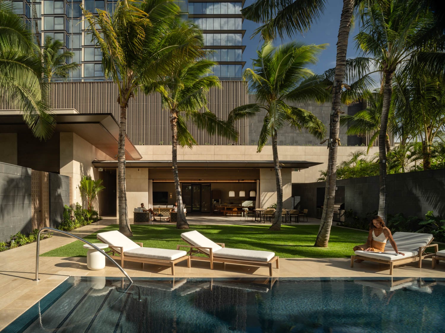 cream loungers by palm trees and pool