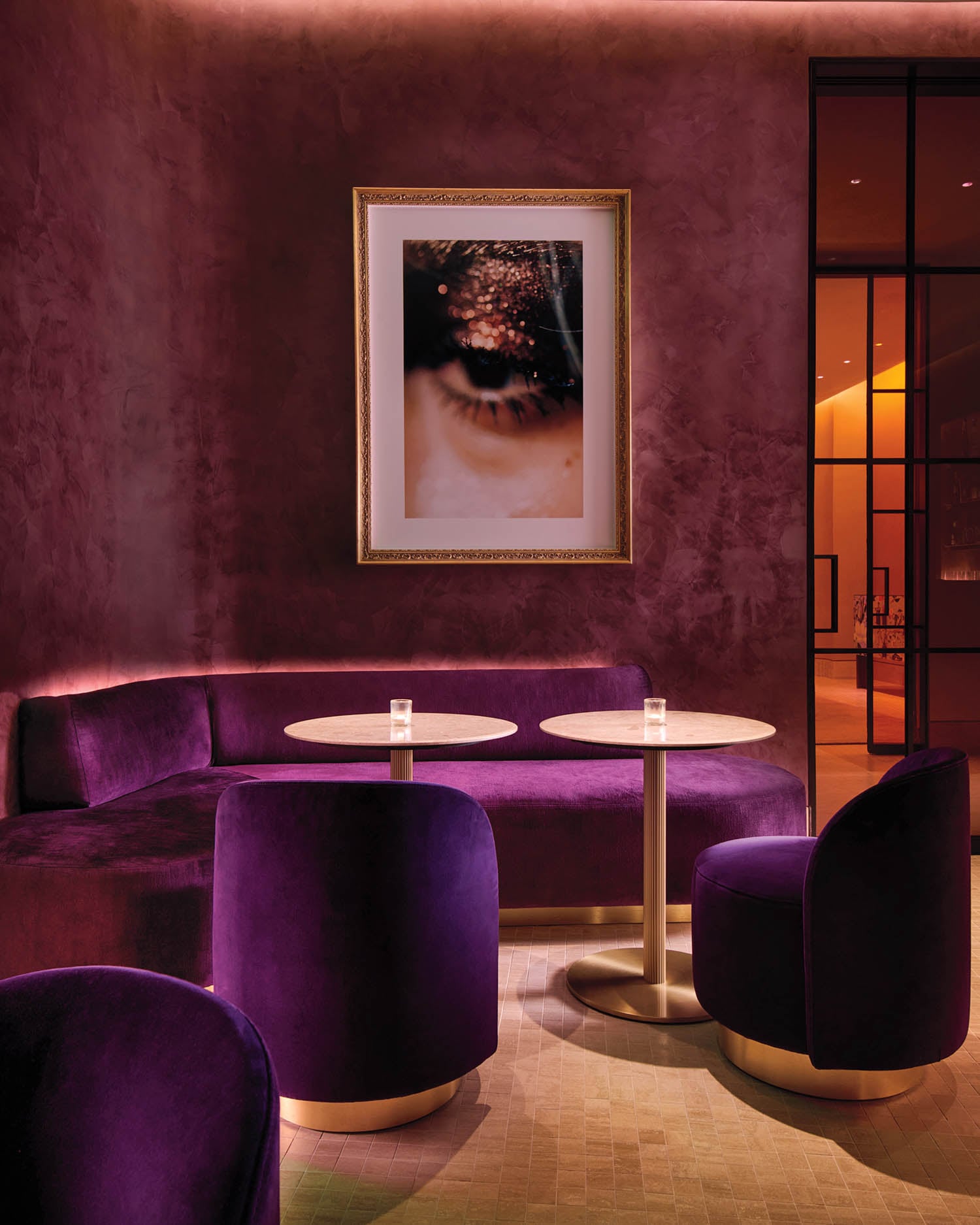 a purple lounge area with velvet banquet seating