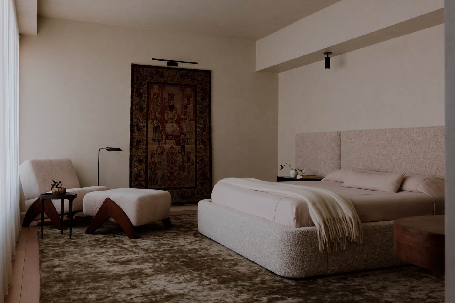 primary bedroom with shearling chair and a hand-knotted wool rug