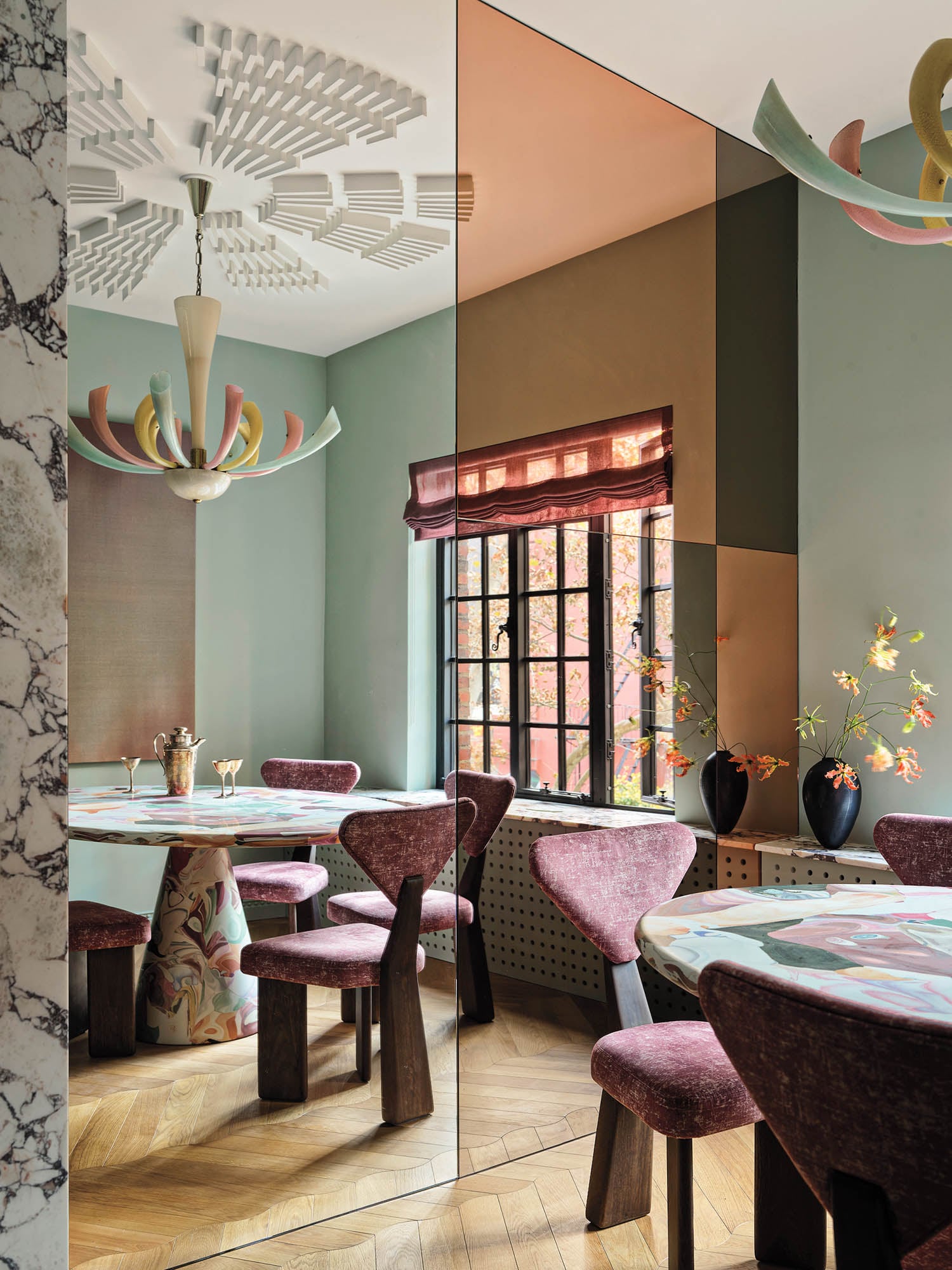 dining room with red chairs, sage green walls and chandelier