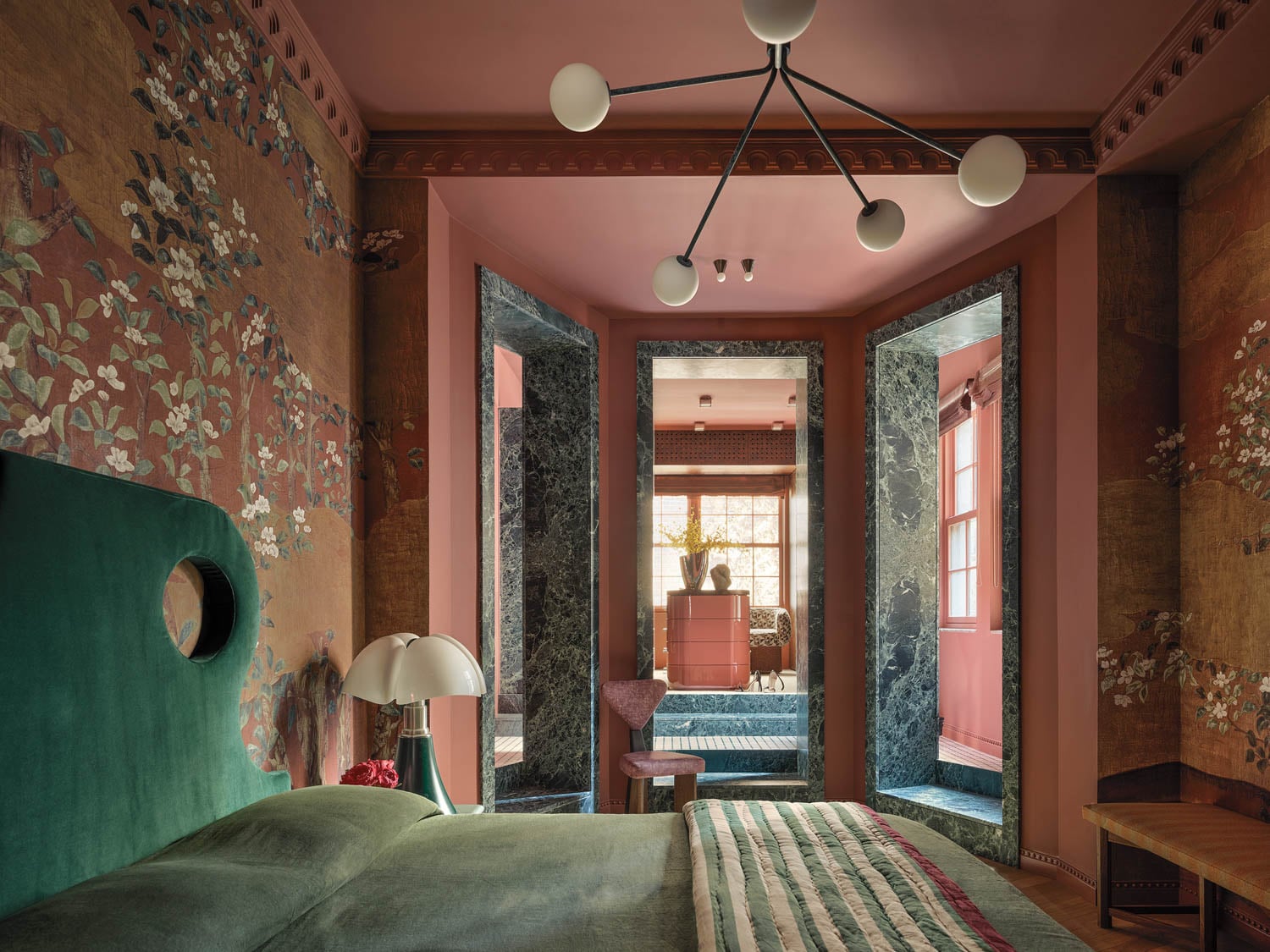 main bedroom area with floral backdrop and dramatic entryway to the bathroom
