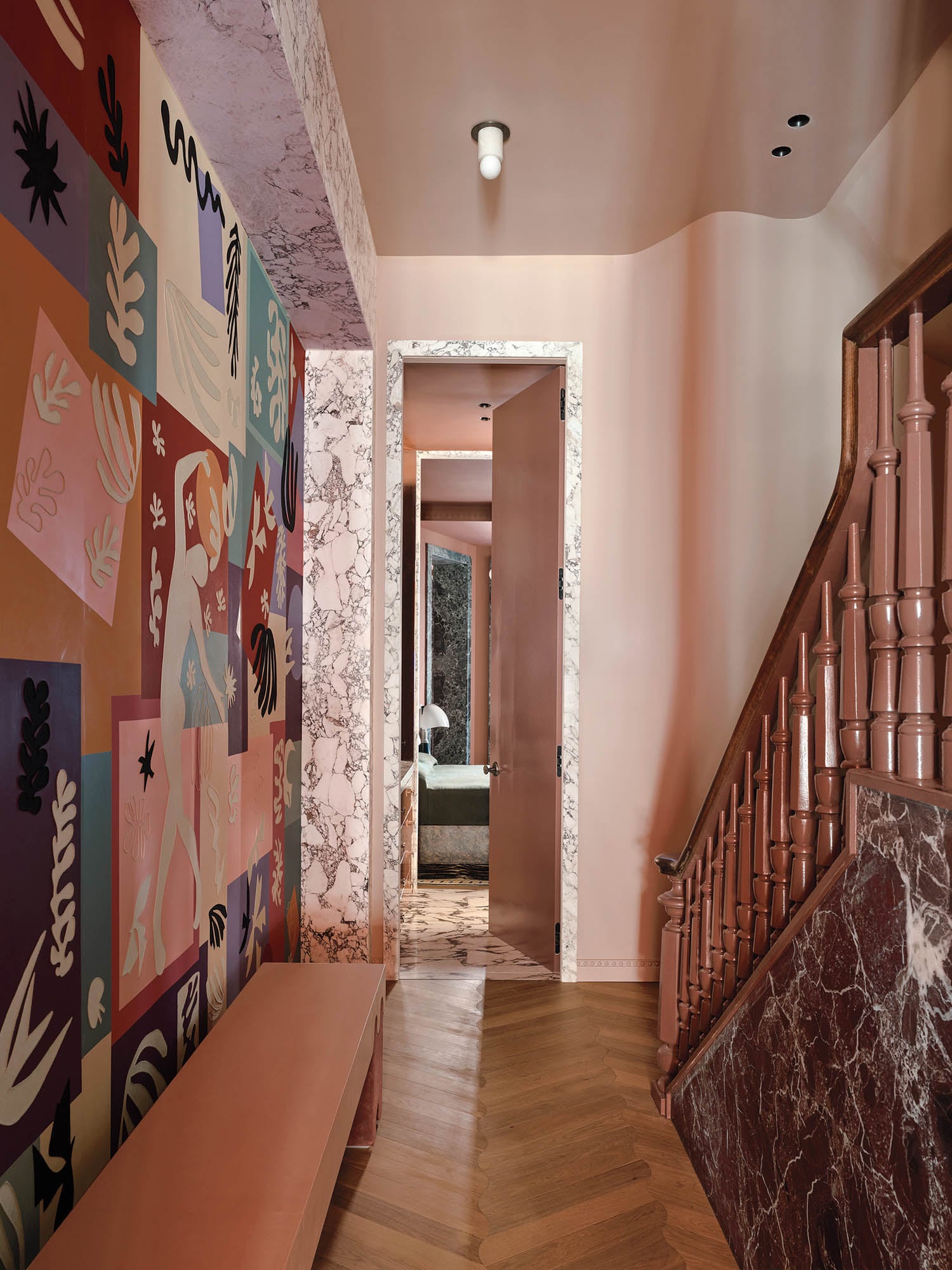 hallway mural with multiple cut out prints and a staircase