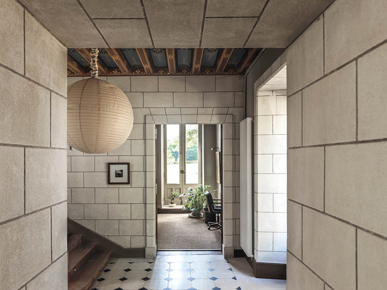 entry with white brick walls and a peek into the study